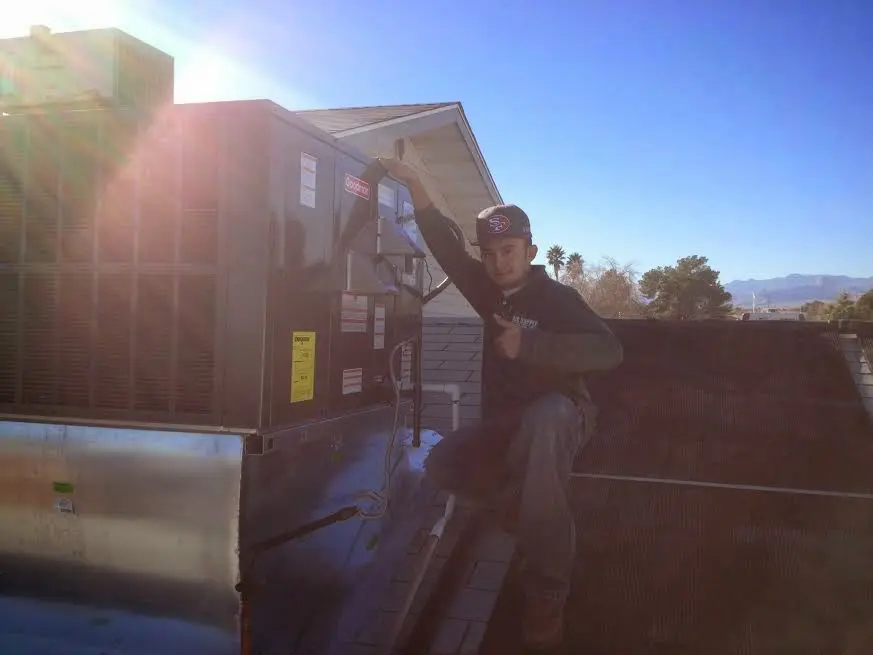 HVAC technician performing Boiler Repair on a rooftop unit in Traverse City